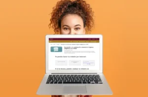 Joven exhibe una computadora con la interfaz de la página del IMSS para realizar trámites en línea